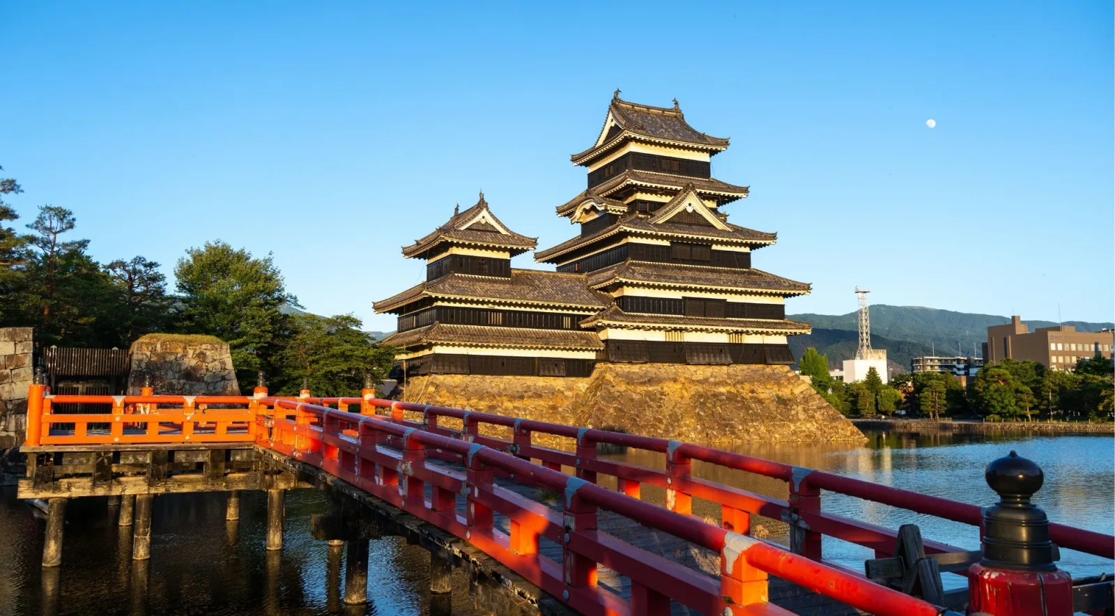 Matsumoto Castle reflected in its moat under a clear summer sky