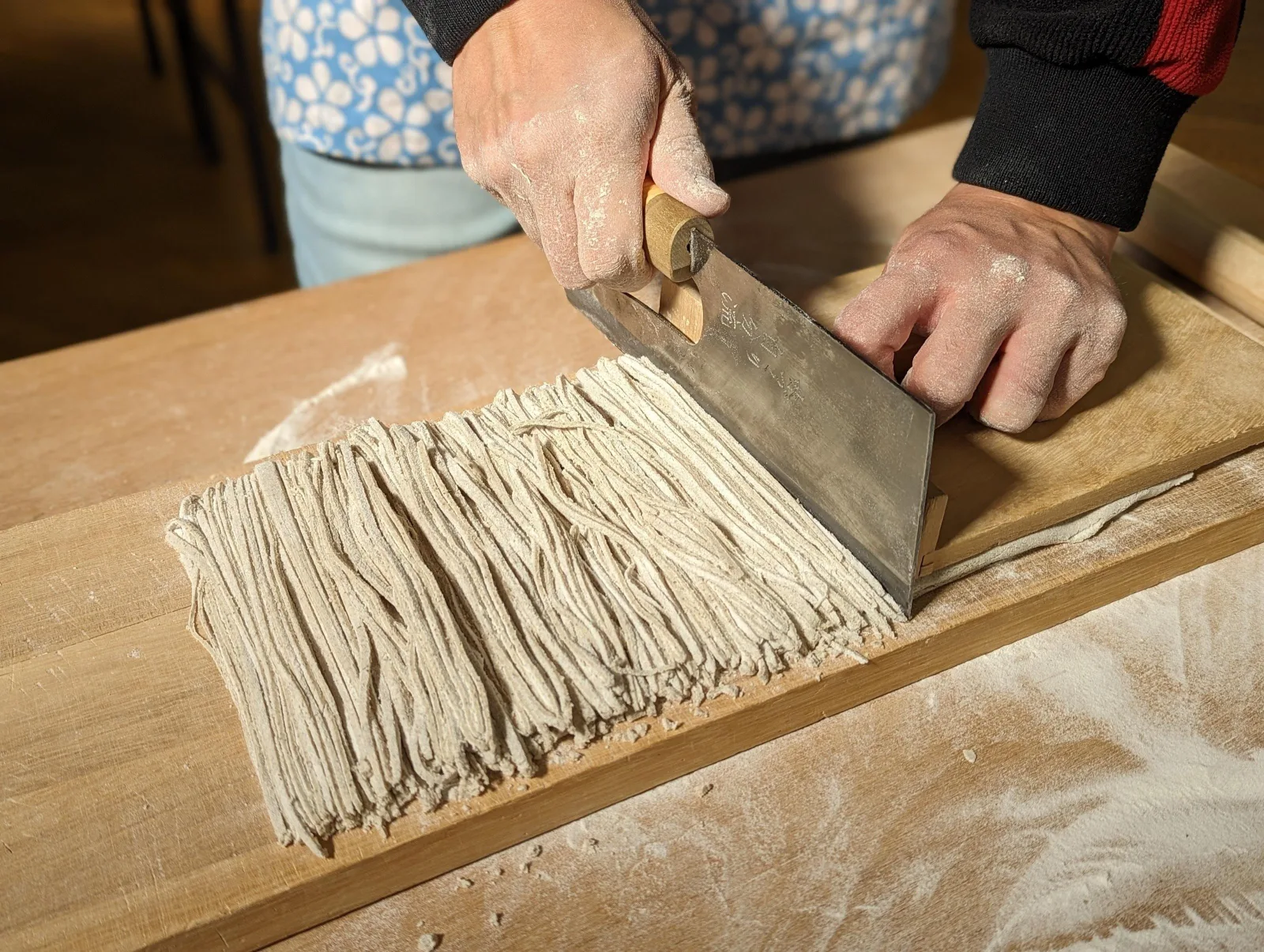Cutting fresh soba noodles with a traditional soba knife